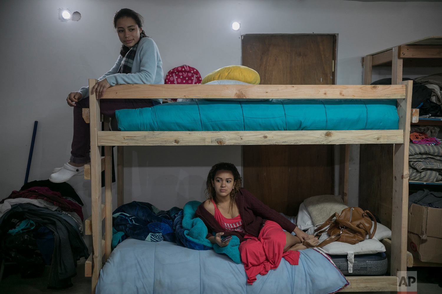  EL Salvador migrant Xiomara, 13, sits atop the bunk bed she shares with 18-year-old Valeria Ramos of Honduras, at the Agape World Mission shelter in Tijuana, Mexico, Feb. 4, 2019. (AP Photo/Emilio Espejel) 
