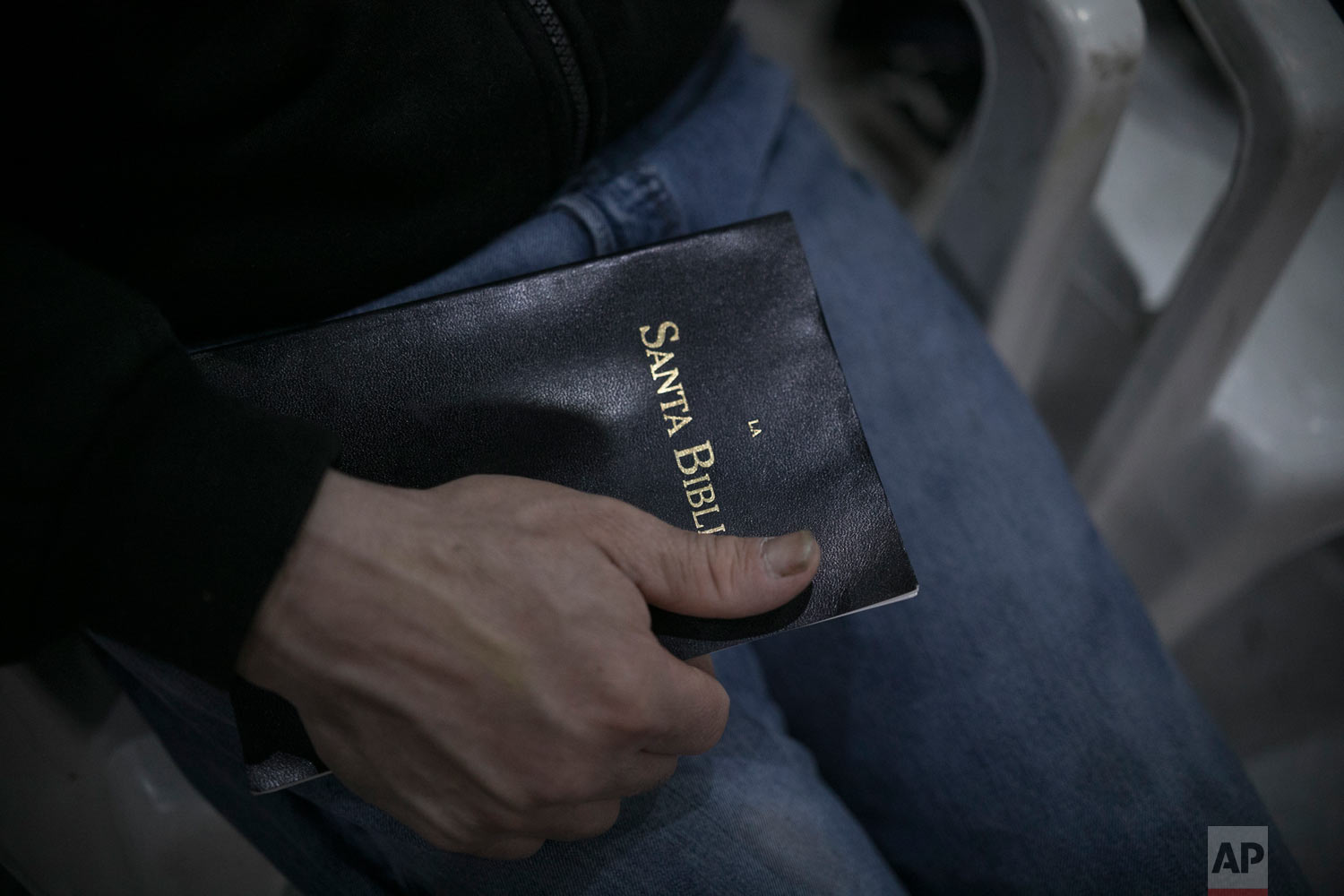  A migrant from Honduras holds a bible during a Christian religious service at the Agape World Mission shelter in Tijuana, Mexico, Feb. 8, 2019. (AP Photo/Emilio Espejel) 