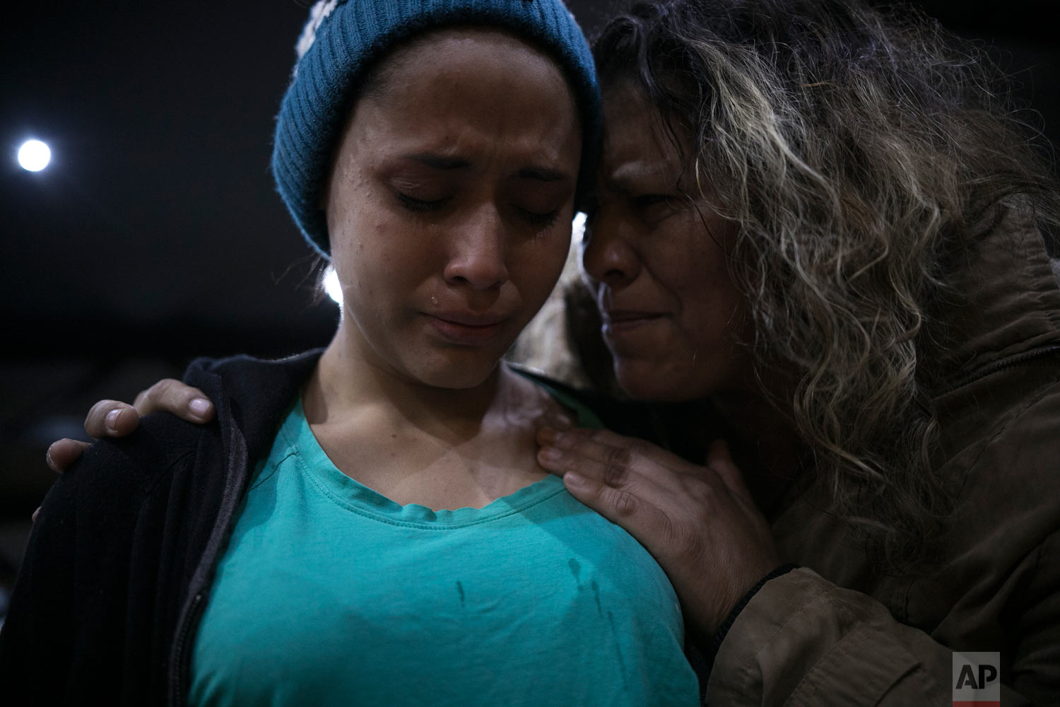  Pregnant 15-year-old El Salvador migrant Milagro de Jesus Henriquez Ayala, is comforted by a local church member as she cries during a Christian religious service at the Agape World Mission shelter in Tijuana, Mexico, Feb. 8, 2010. (AP Photo/Emilio 