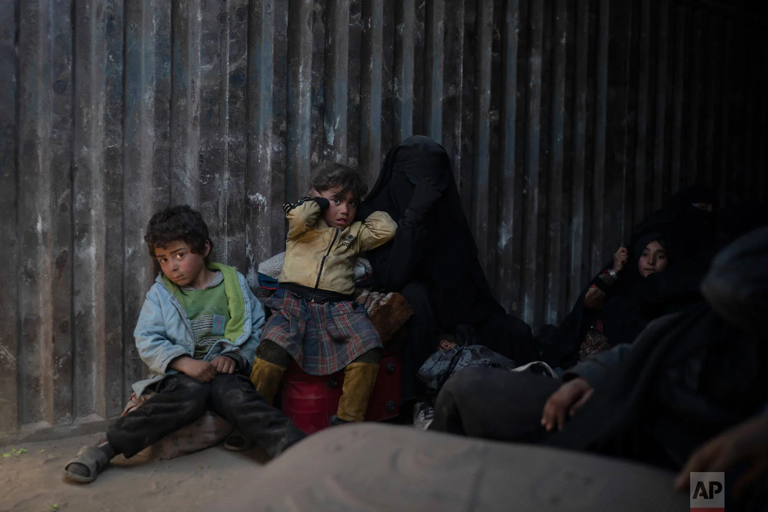 Women and children ride in the back of a truck that is part of a convoy evacuating hundreds out of the last territory held by Islamic State militants in Baghouz, eastern Syria, Feb. 20, 2019. (AP Photo/Felipe Dana)