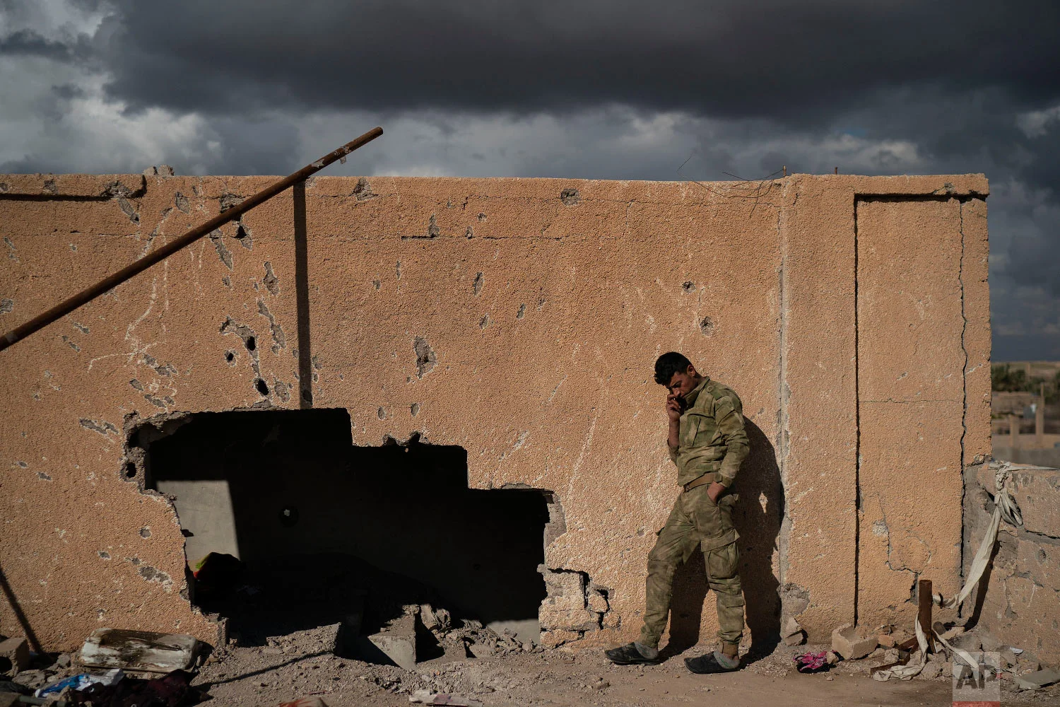  A U.S.-backed Syrian Democratic Forces (SDF) fighter talks on his phone from atop a building recently taken by SDF as fight against Islamic State militants continue in the village of Baghouz, Syria, Feb. 17, 2019. (AP Photo/Felipe Dana) 