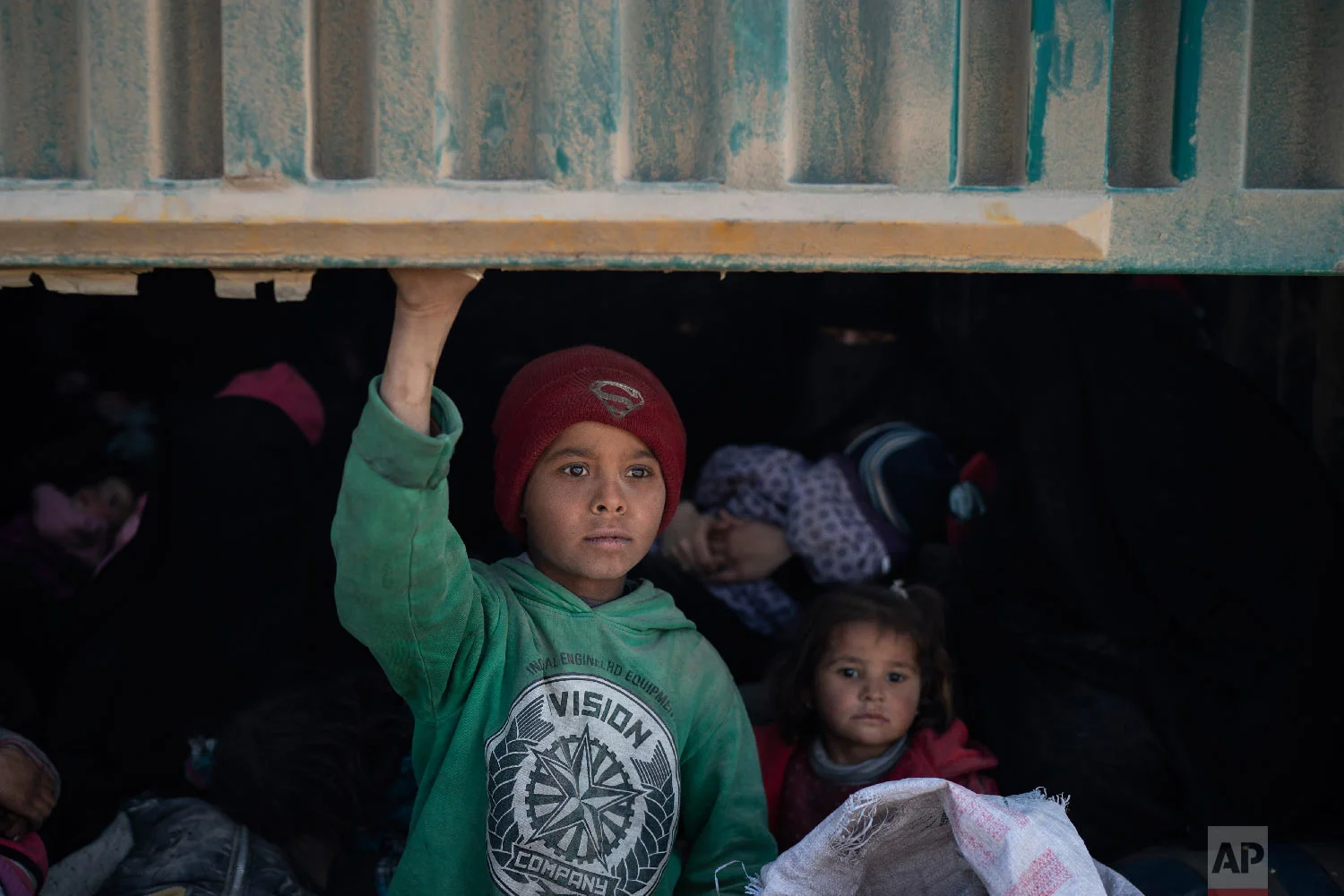  Children ride in the back of a truck that is part of a convoy evacuating hundreds out of the last territory held by Islamic State militants, in Baghouz, eastern Syria, Feb. 20, 2019. (AP Photo/Felipe Dana) 