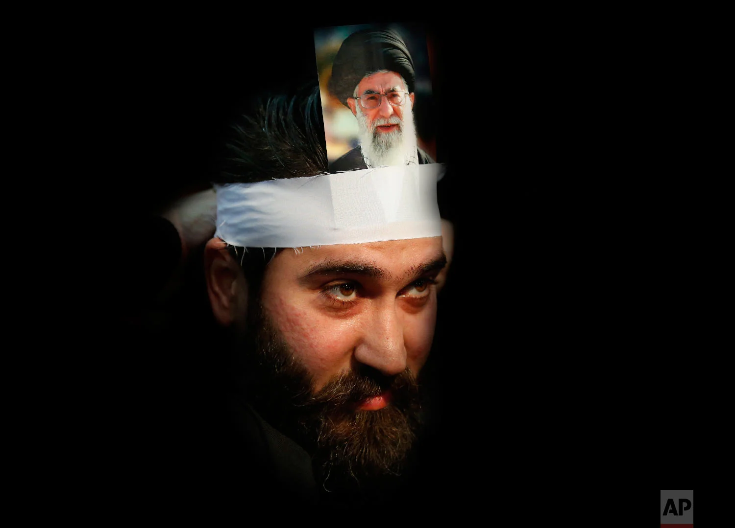  A Hezbollah supporter hangs a portrait on his head of Iran's supreme leader Ayatollah Ali Khamenei, during a rally to commemorate the 40th anniversary of Iran's Islamic Revolution, in southern Beirut, Lebanon, Feb. 6, 2019. (AP Photo/Hussein Malla) 