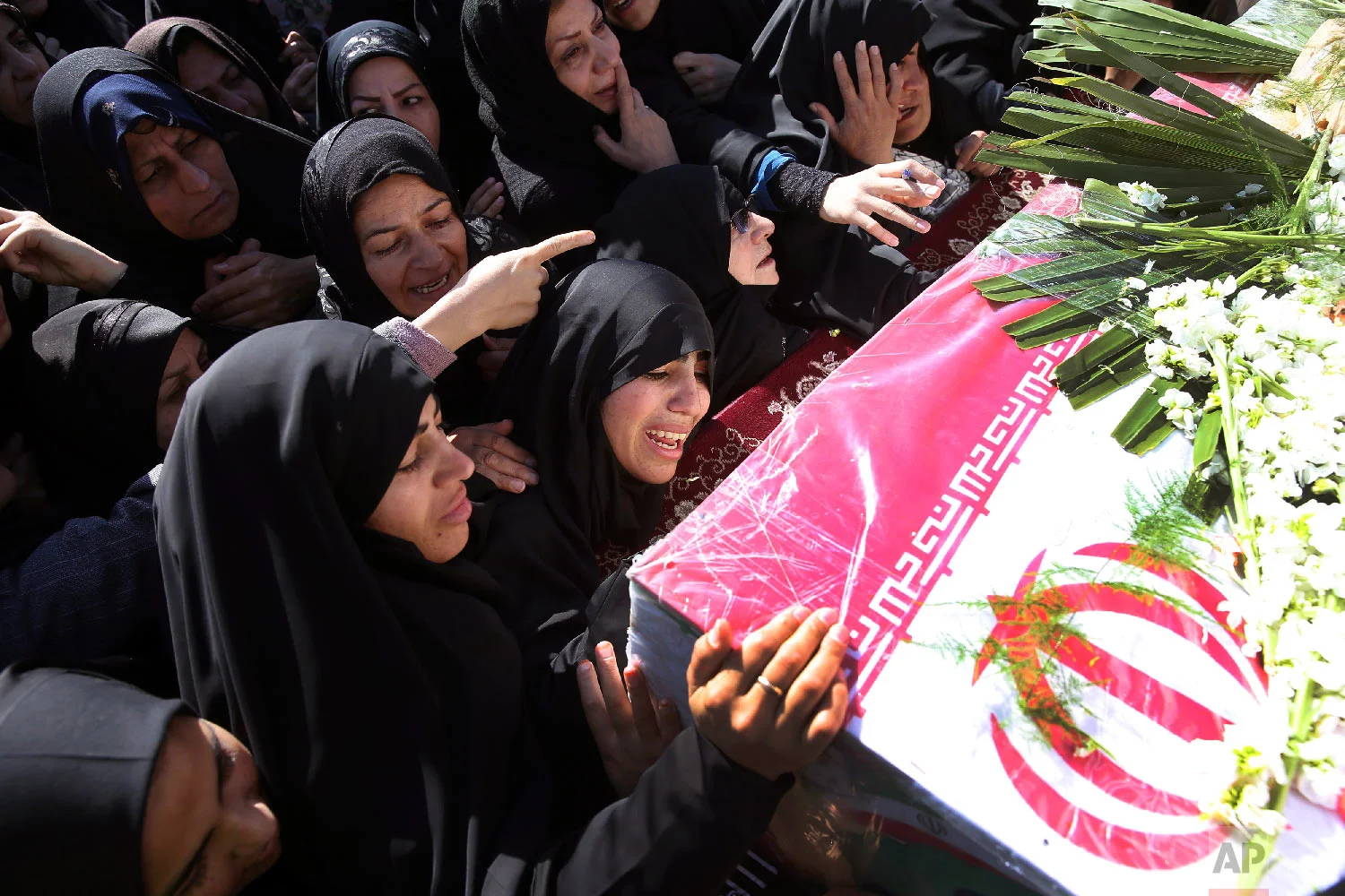  Mourners reach out to touch the caskets of those killed in a suicide car bombing that targeted members of Iran's powerful Revolutionary Guard in earlier in the week, killing at least 27 people, in Isfahan, Iran, Feb. 16, 2019. (AP Photo/Ebrahim Noro