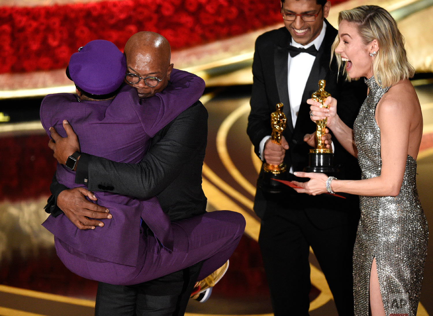 Samuel L. Jackson, center left, embraces Spike Lee, winner of the award for best adapted screenplay for "BlacKkKlansman" as Brie Larson, right, looks on, at the Oscars on Sunday, Feb. 24, 2019, at the Dolby Theatre in Los Angeles. (Photo by Chris Pi