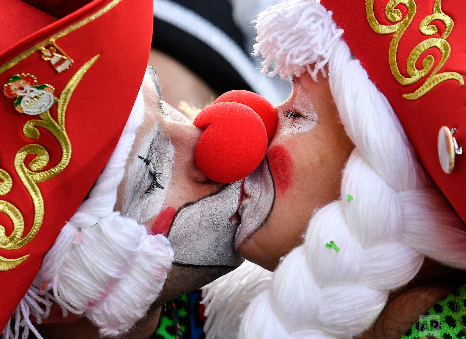 Two revelers kiss for photographers in Cologne's city center when thousands of revelers dressed in carnival costumes celebrate the start of the street carnival in Cologne, Germany, Thursday, Feb. 28, 2019. (AP Photo/Martin Meissner)