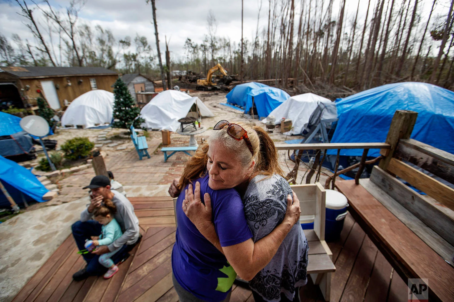 Diahn “Shelly” Summers, right, embraces Lori Hogan, who is currently living in a tent in Summers' backyard months after Hurricane Michael hit in Youngstown, Fla, Wednesday, Jan. 23, 2019. (AP Photo/David Goldman)