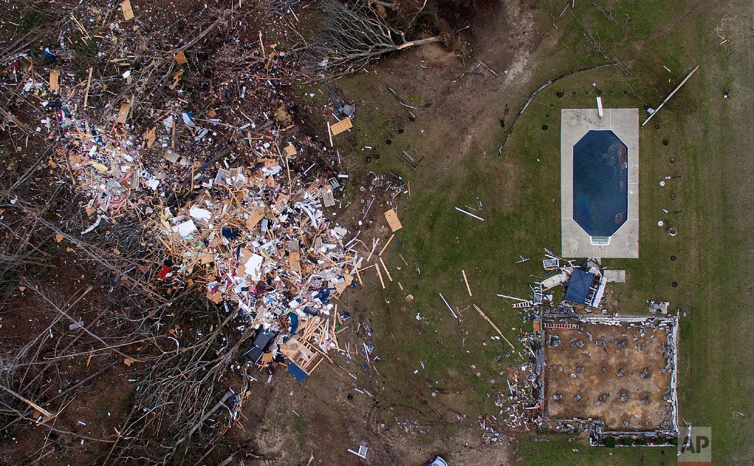 Debris from a home litters a yard the day after a tornado blew it off its foundation, lower right, in Beauregard, Ala., March 4, 2019. (AP Photo/David Goldman)