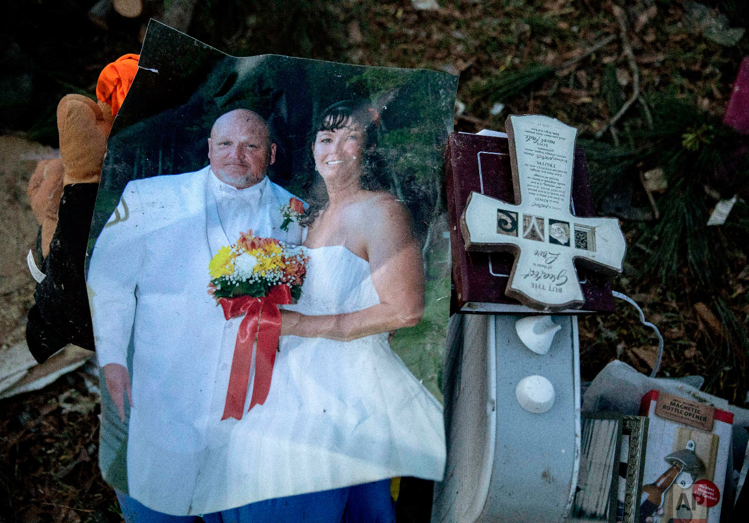 A wedding photo of Carol Dean and David Wayne Dean sits in a pile of personal items Carol Dean recovered in Beauregard, Ala., March 4, 2019. (AP Photo/David Goldman)