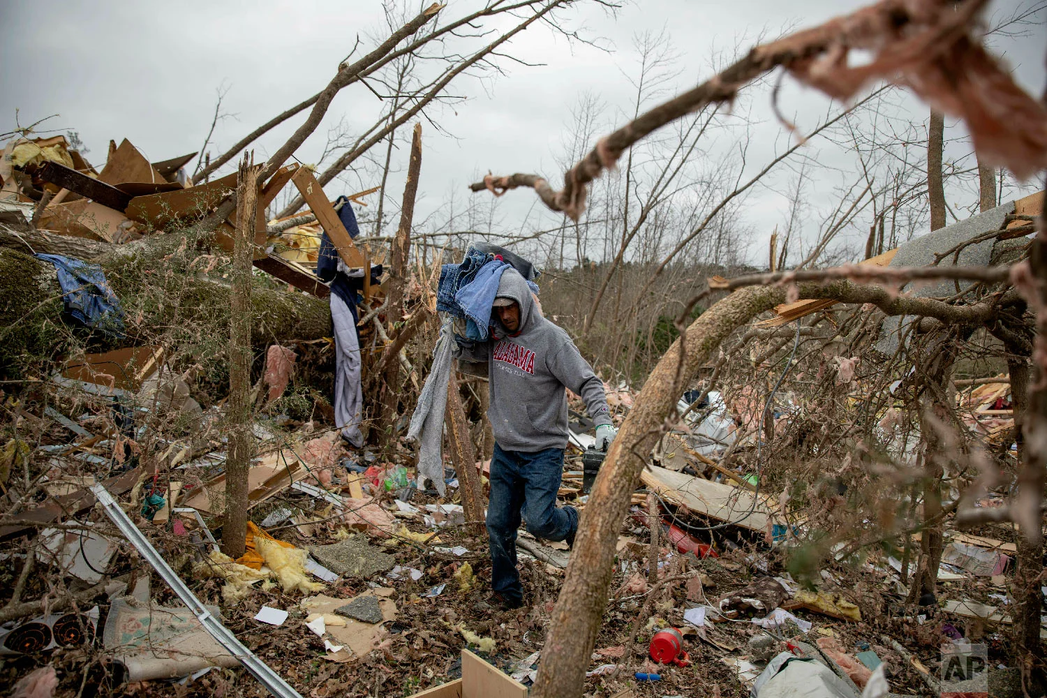 Danny Allen helps recover belongings while sifting through the debris of a friend's home destroyed by a tornado in Beauregard, Ala., March 4, 2019. (AP Photo/David Goldman)