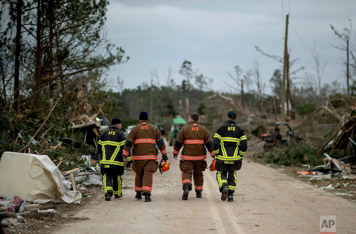 First responders walk through a neighborhood heavily damaged by a tornado a day earlier in Beauregard, Ala., March 4, 2019. (AP Photo/David Goldman)