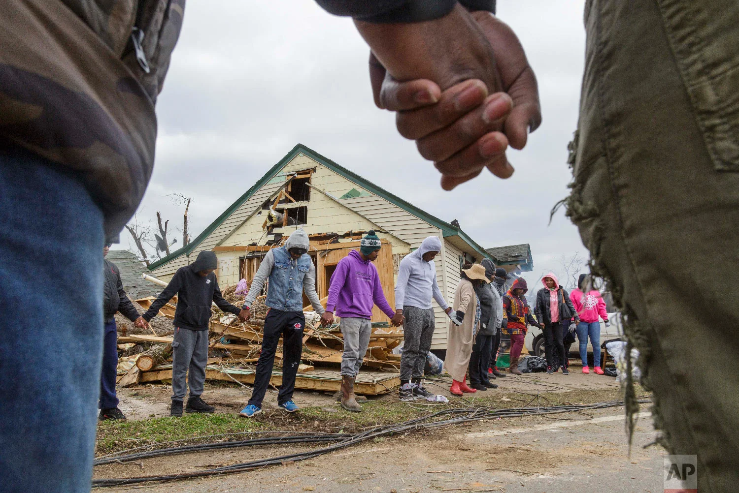 Residents of Talbotton, Ga., pray together outside a home destroyed by a tornado the day after storms battered Alabama and Georgia, March 4, 2019. (Grant Blankenship/The Macon Telegraph via AP)