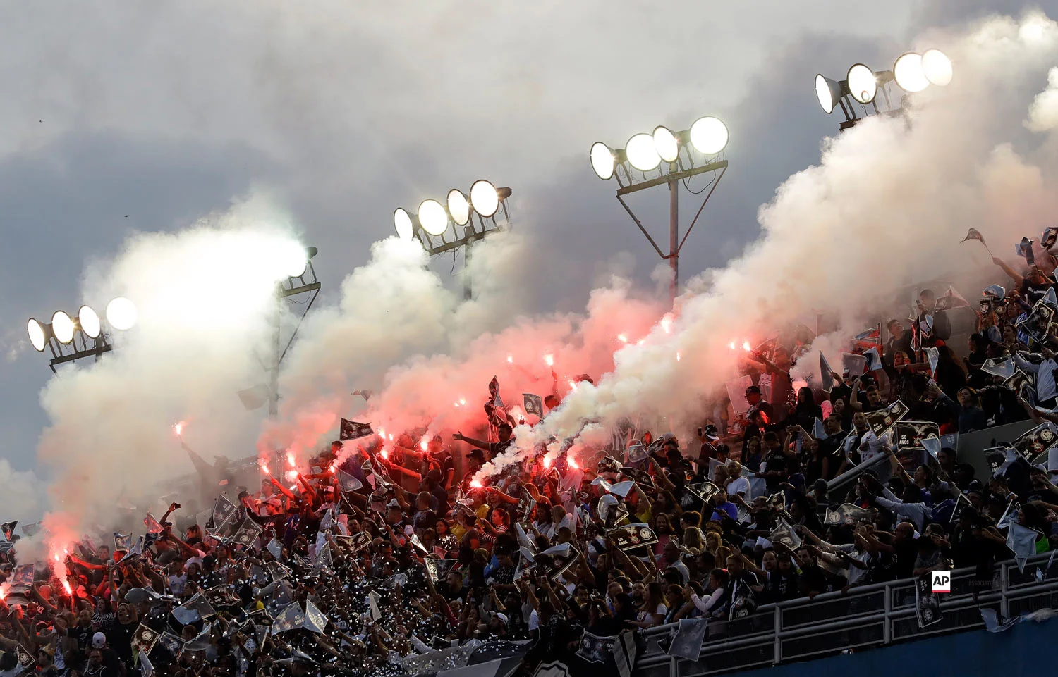 Fans cheer and light flares during the Gavioes da Fiel samba school carnival parade in Sao Paulo, Brazil, Sunday, March 3, 2019. (AP Photo/Andre Penner)