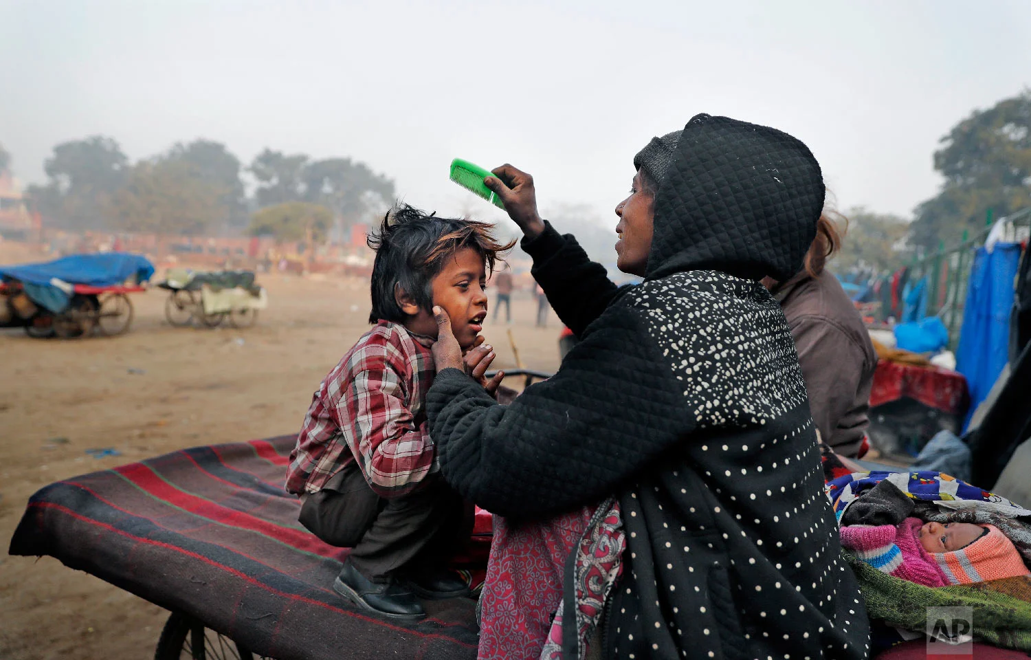 Ruby Khan helps her 7-year-old son Farmaan get ready for school in New Delhi, India on In this Jan. 18, 2019. (AP Photo/Altaf Qadri)