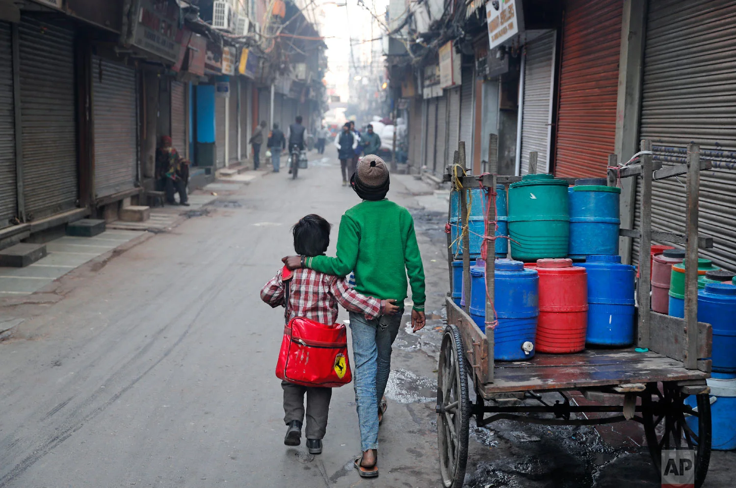 13-year-old Ajmeri, right, walks his younger brother Farmaan to school in New Delhi, India, on Jan. 18, 2019. (AP Photo/Altaf Qadri)