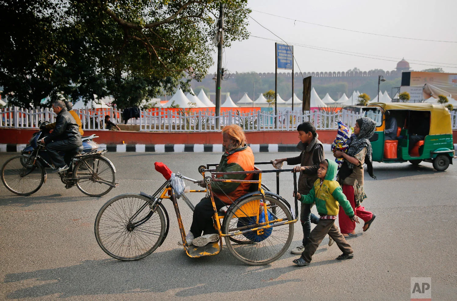 The Khan family, led by Nisar Khan,make their way to a temple to receive donations and free food in New Delhi, India on Feb. 1, 2019. (AP Photo/Altaf Qadri)