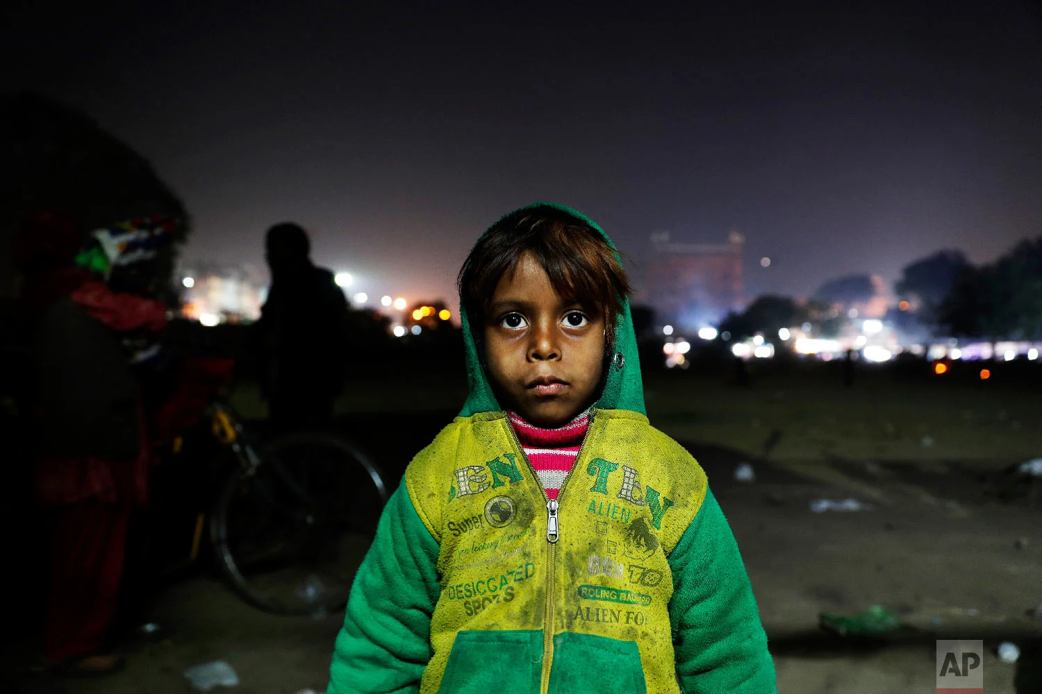 7-year-old Farmaan poses for a photograph near his home, a wooden fruit vendor's cart, in New Delhi, India on Jan. 18, 2019. (AP Photo/Altaf Qadri)