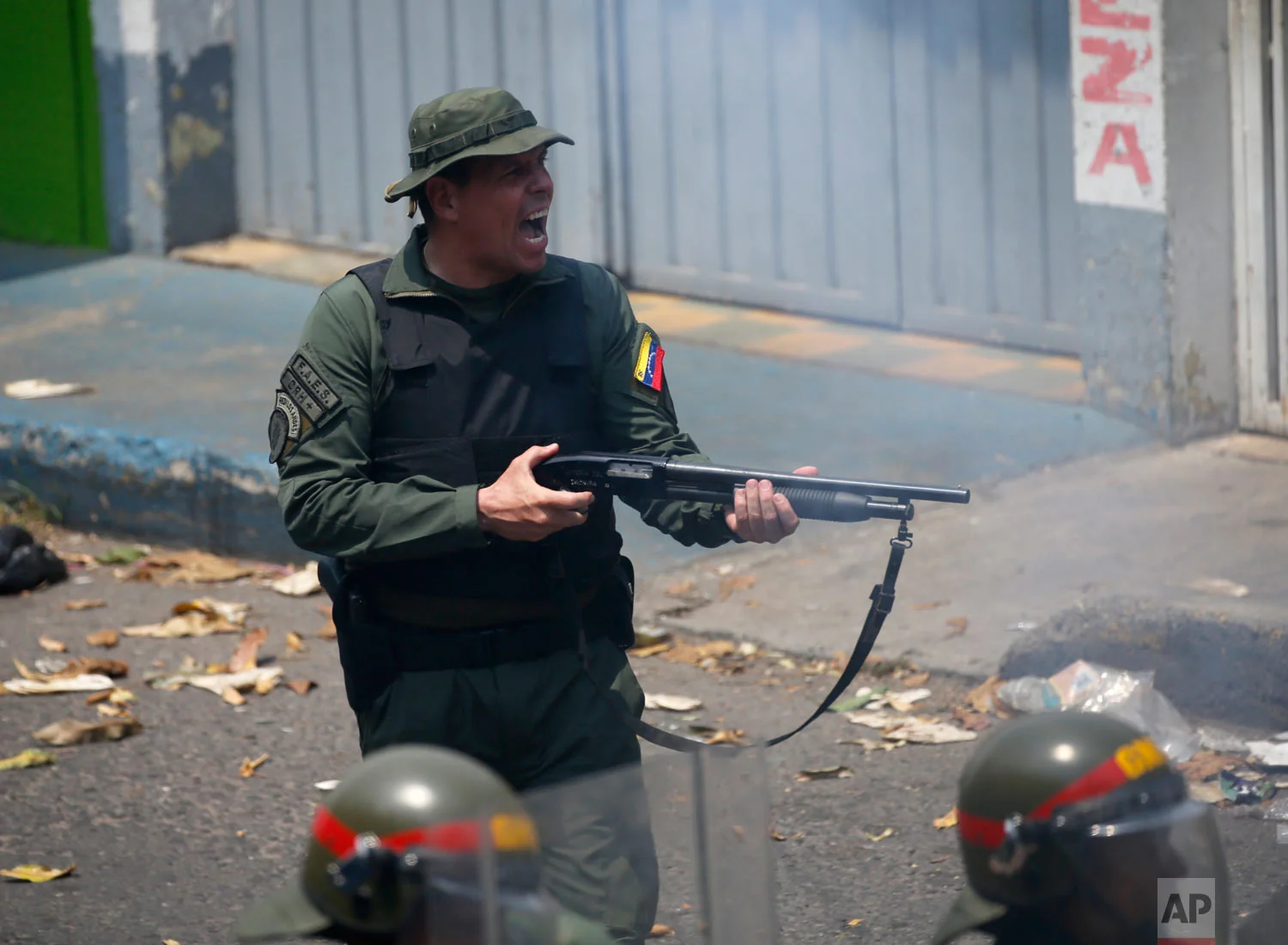  An officer of the Bolivarian National Guard fires his shotgun during clashes in Urena, Venezuela, near the border with Colombia, Feb. 23, 2019. (AP Photo/Fernando Llano) 