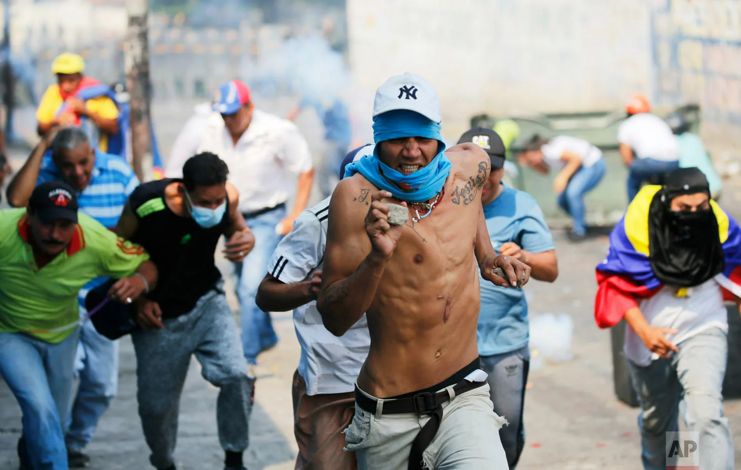  Demonstrators run from tear gas fired by Bolivarian National Guard officers during clashes in Urena, Venezuela, near the border with Colombia, Feb. 23, 2019.(AP Photo/Fernando Llano) 