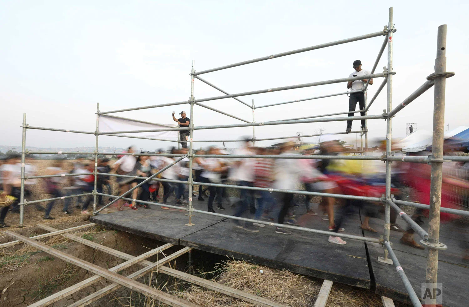 People stream in prior to the Venezuela Aid Live concert on the Colombian side of Tienditas International Bridge on the outskirts of Cucuta, Colombia, on the border with Venezuela, Feb. 22, 2019. (AP Photo/Fernando Vergara)