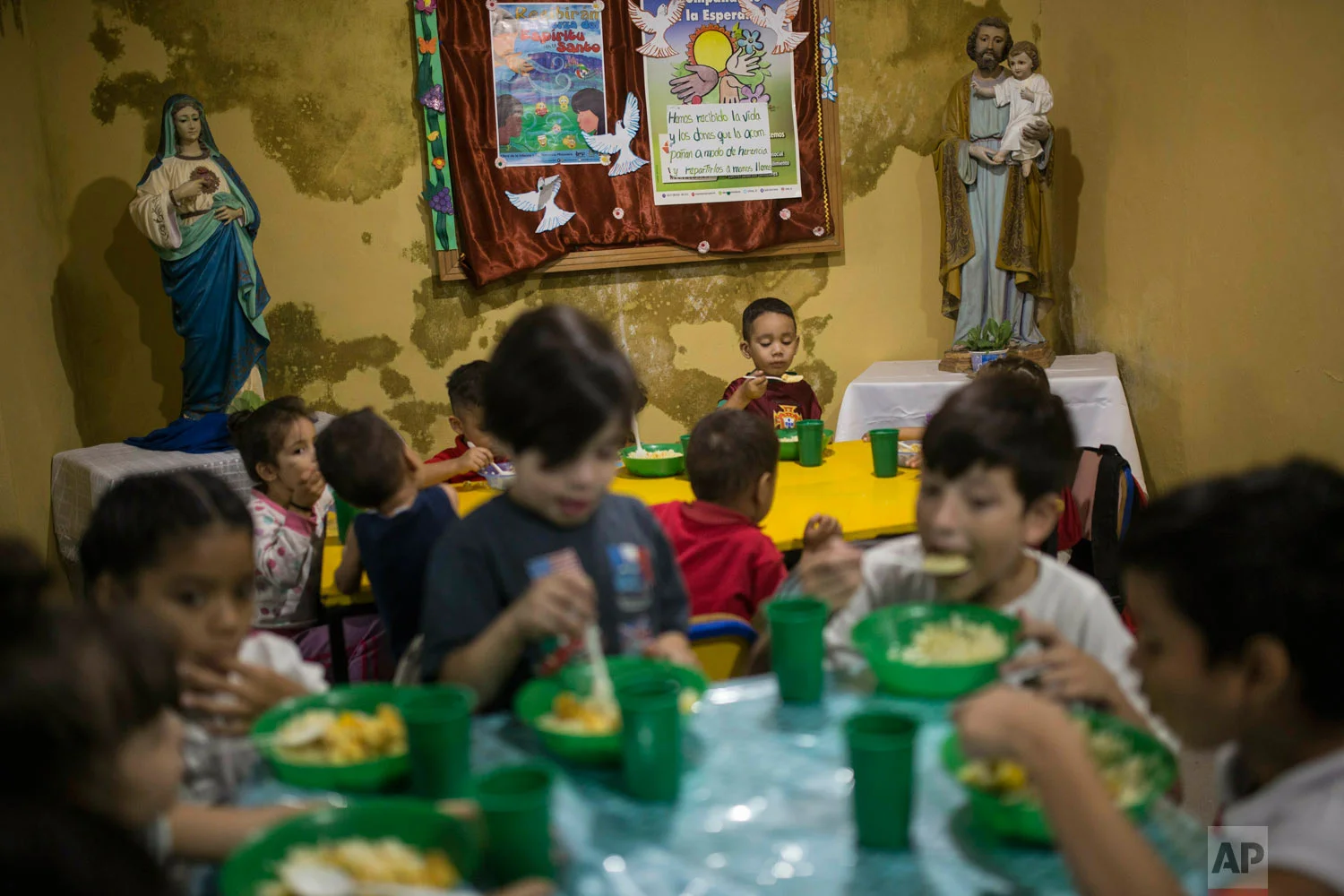 Children have lunch in San Antonio de Padua soup kitchen in the Petare slum, in Caracas, Venezuela, Feb. 11, 2019. (AP Photo/Rodrigo Abd)