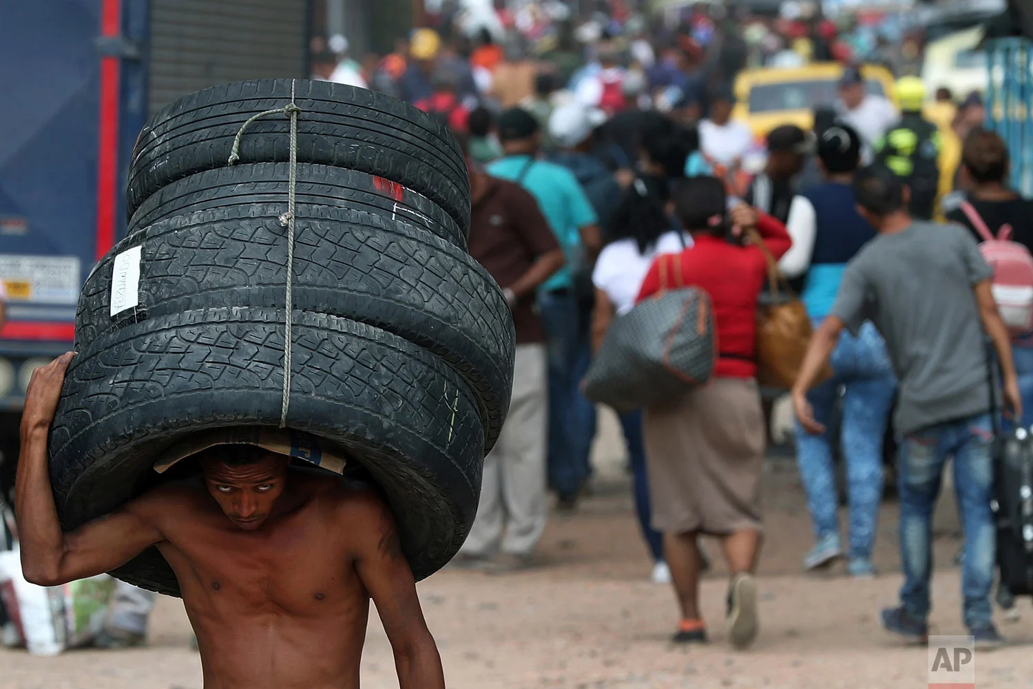 A man hauls used tires back to Venezuela, using a blind spot on the border near the closed Simon Bolivar International Bridge, in La Parada, Colombia, Feb. 28, 2019. (AP Photo/Martin Mejia)