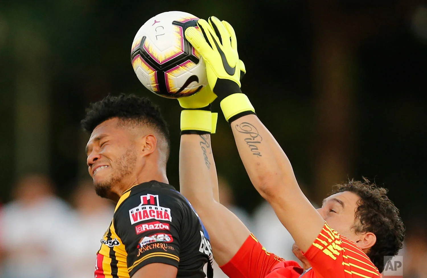 Paraguay's Libertad goalkeeper Martin Silva catches the ball preventing Bolivia's The Strongest Rolando Blackburn from heading the ball during a Copa Libertadores soccer game, in Asuncion, Paraguay, Feb. 13, 2019. (AP Photo/Jorge Saenz)