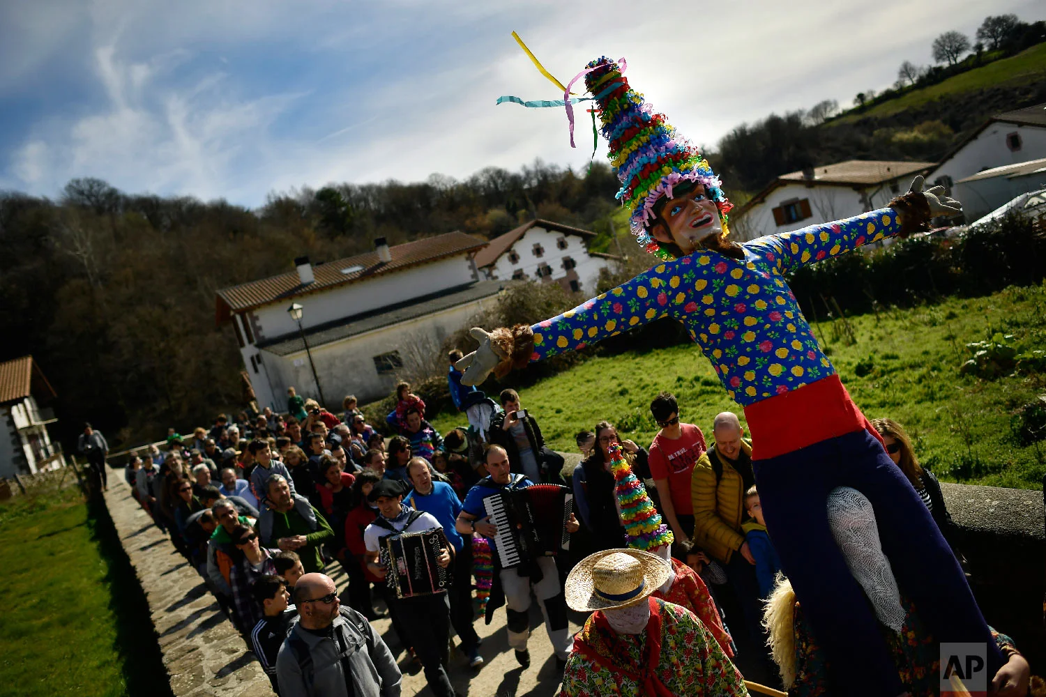 People carry a giant "Miel Otxin'', the symbol of the carnival, during an ancient rural carnival in the small Pyrenees village of Lantz, northern Spain, Sunday, March 3, 2019. (AP Photo/Alvaro Barrientos)