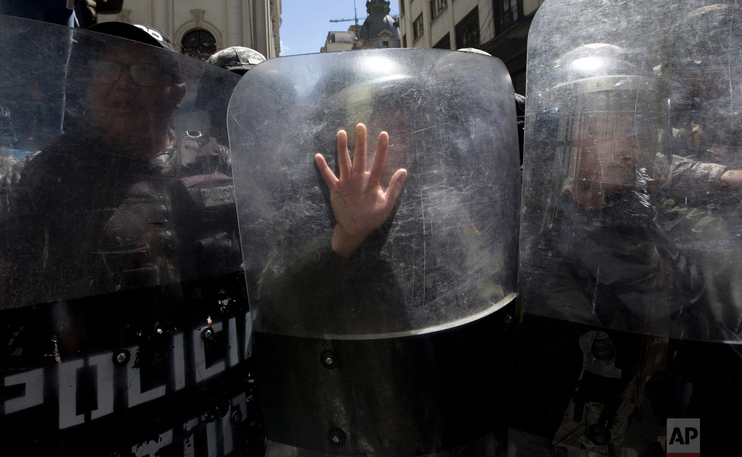  A riot police officer places her hand on her shield as she helps to prevent a march marking International Women's Day from reaching the government palace, in La Paz, Bolivia, on Friday, March 8, 2019. The day has been sponsored by the United Nations