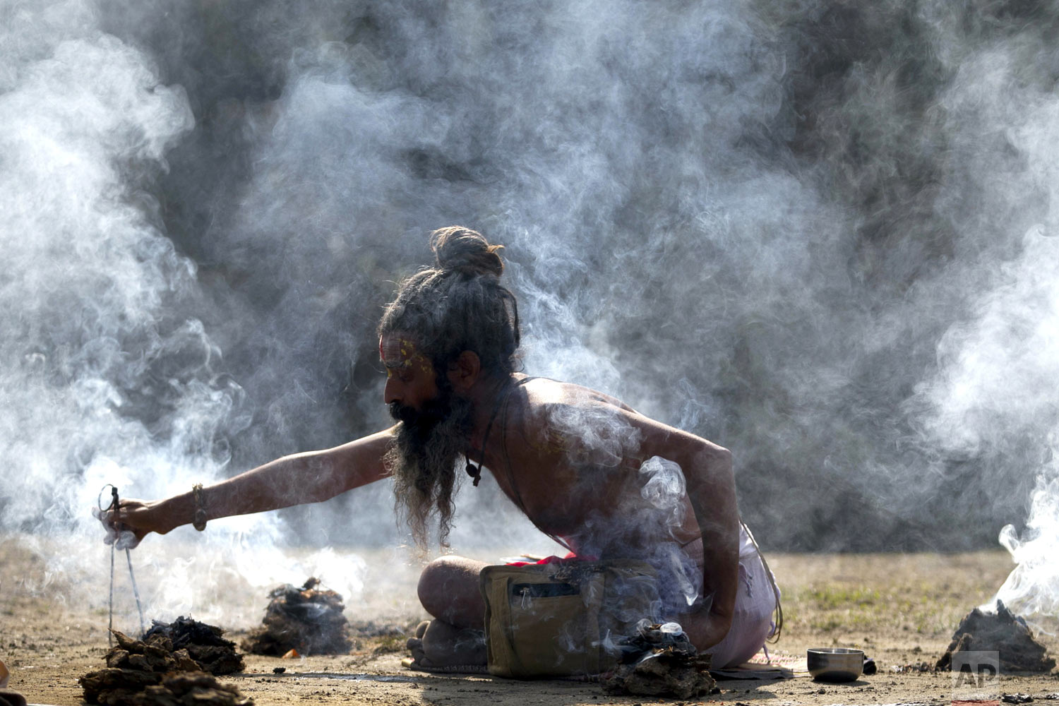  Surrounded by smoke, a Hindu holy man offers prayers at the courtyard of the Pashupatinath Temple during Shivaratri festival in Kathmandu, Nepal, Monday, March 4, 2019. Shivaratri, or the night of Shiva, is dedicated to the worship of Lord Shiva, th