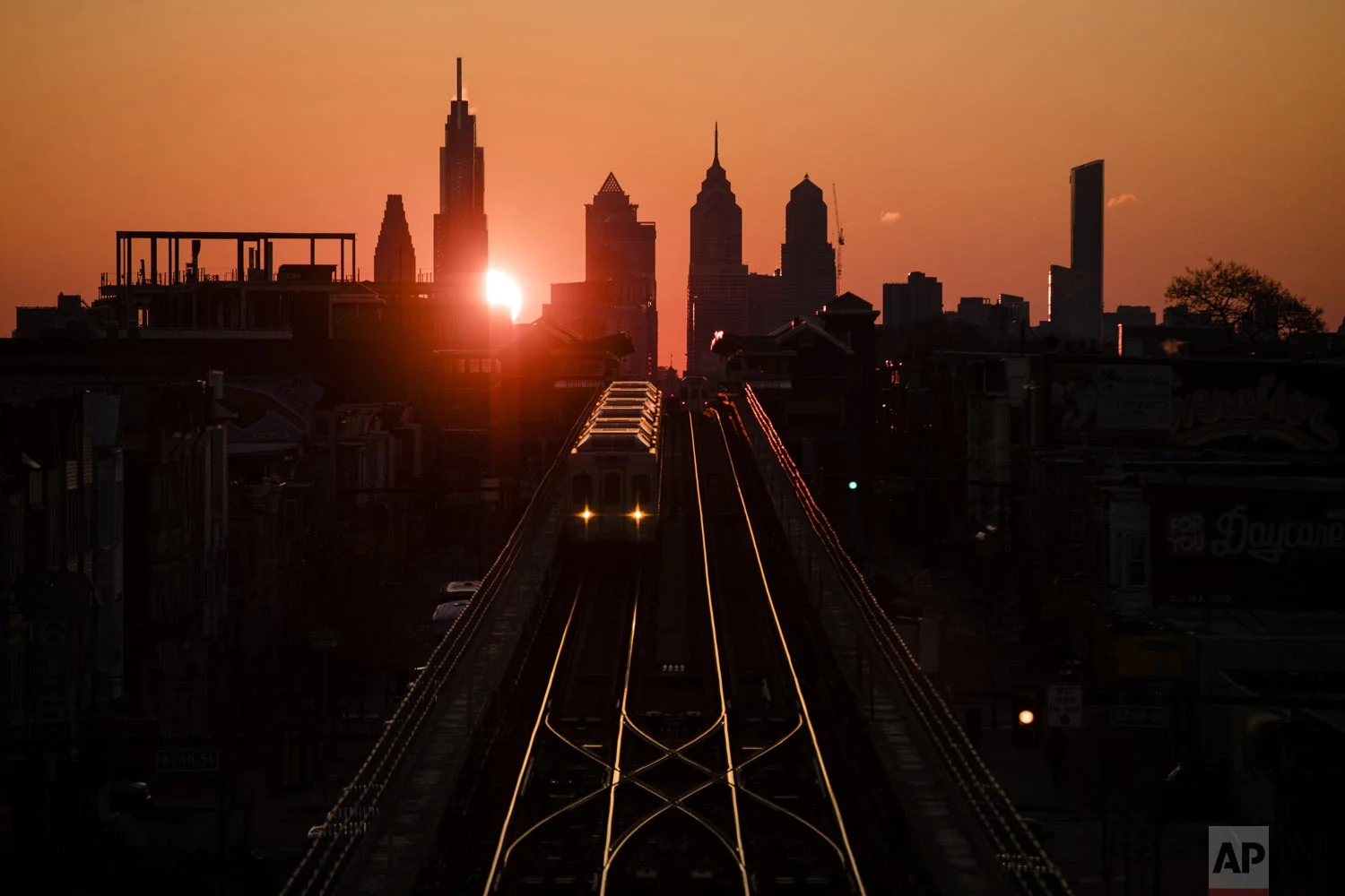 A train heads west as the sun rises from behind the city skyline in Philadelphia, Wednesday, March 6, 2019. The Southeastern Pennsylvania Transportation Authority said members of the Fraternal Order of Transit Police Lodge 109 walked off the job Wednesday. (AP Photo/Matt Rourke)