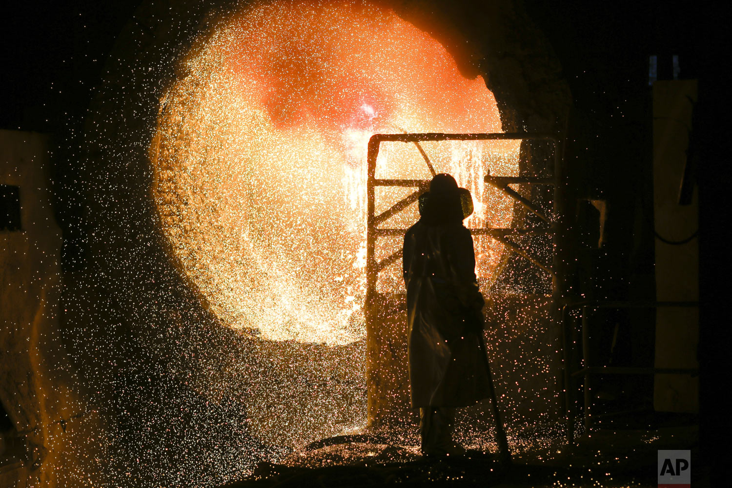  An employee in protective clothing works with a steel pouring ladle during a guided media tour at the steel producer Salzgitter AG in Salzgitter, Tuesday, March 5, 2019. (AP Photo/Markus Schreiber) 