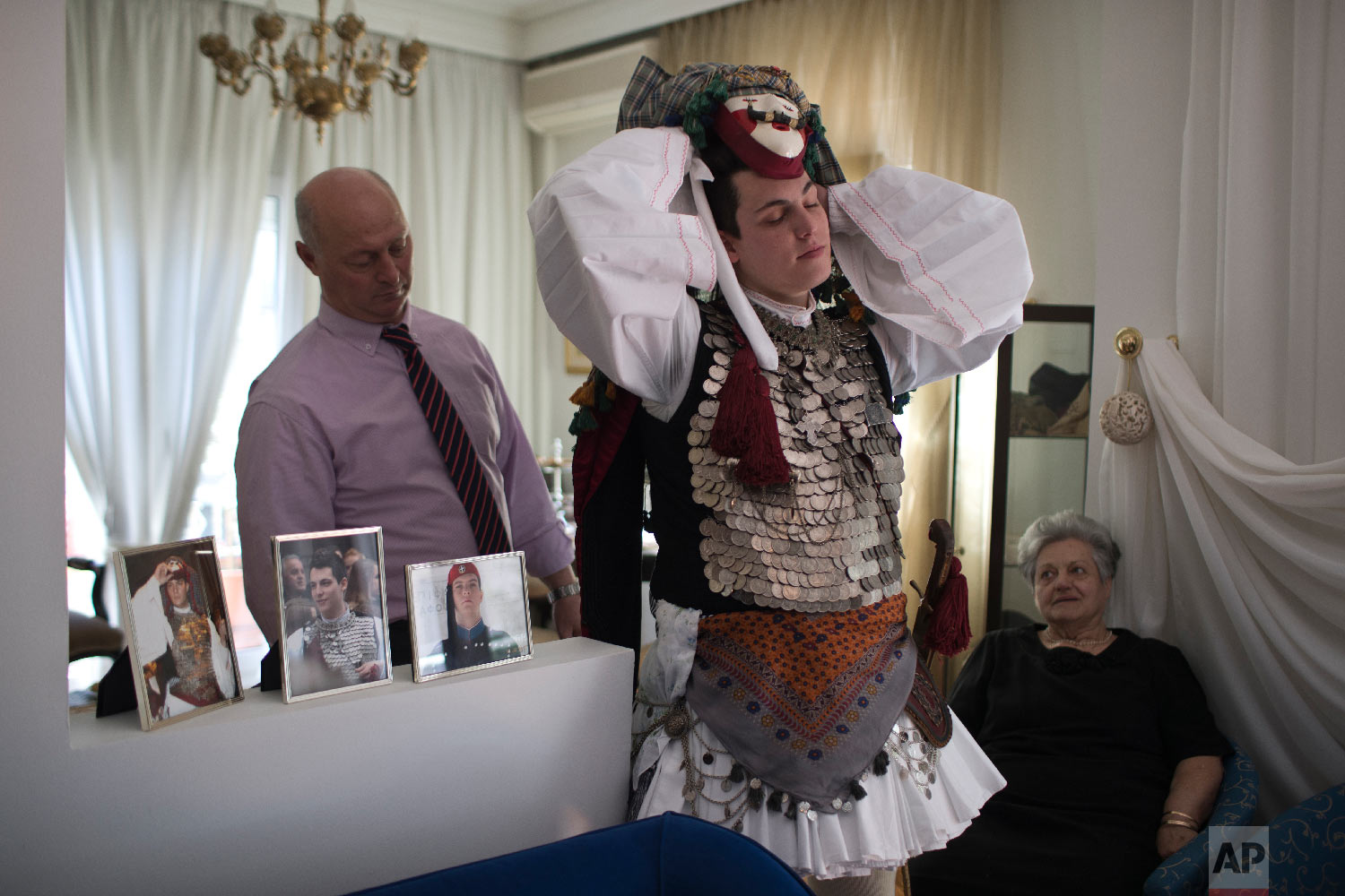 A dancer gets dressed at his home as he prepares to compete in the Boules and Genitsaroi carnival parade in the town of Naousa, northern Greece on March 10, 2019. (AP Photo/Petros Giannakouris)