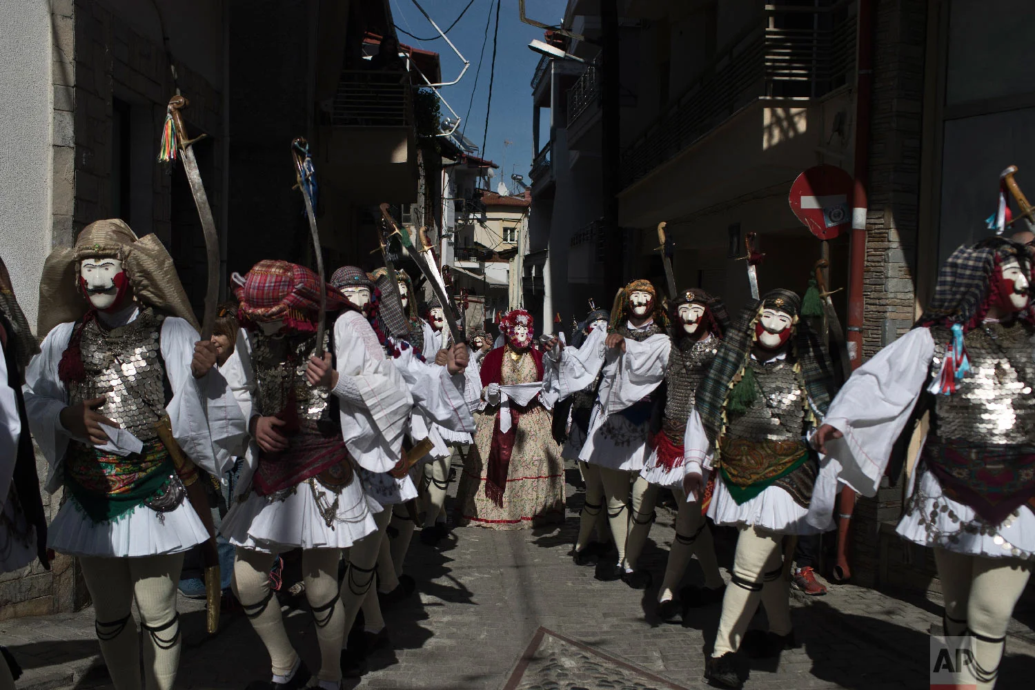 Dancers with masks and traditional costumes perform in the Boules and Genitsaroi carnival parade in the town of Naousa, northern Greece on March 10, 2019. (AP Photo/Petros Giannakouris)