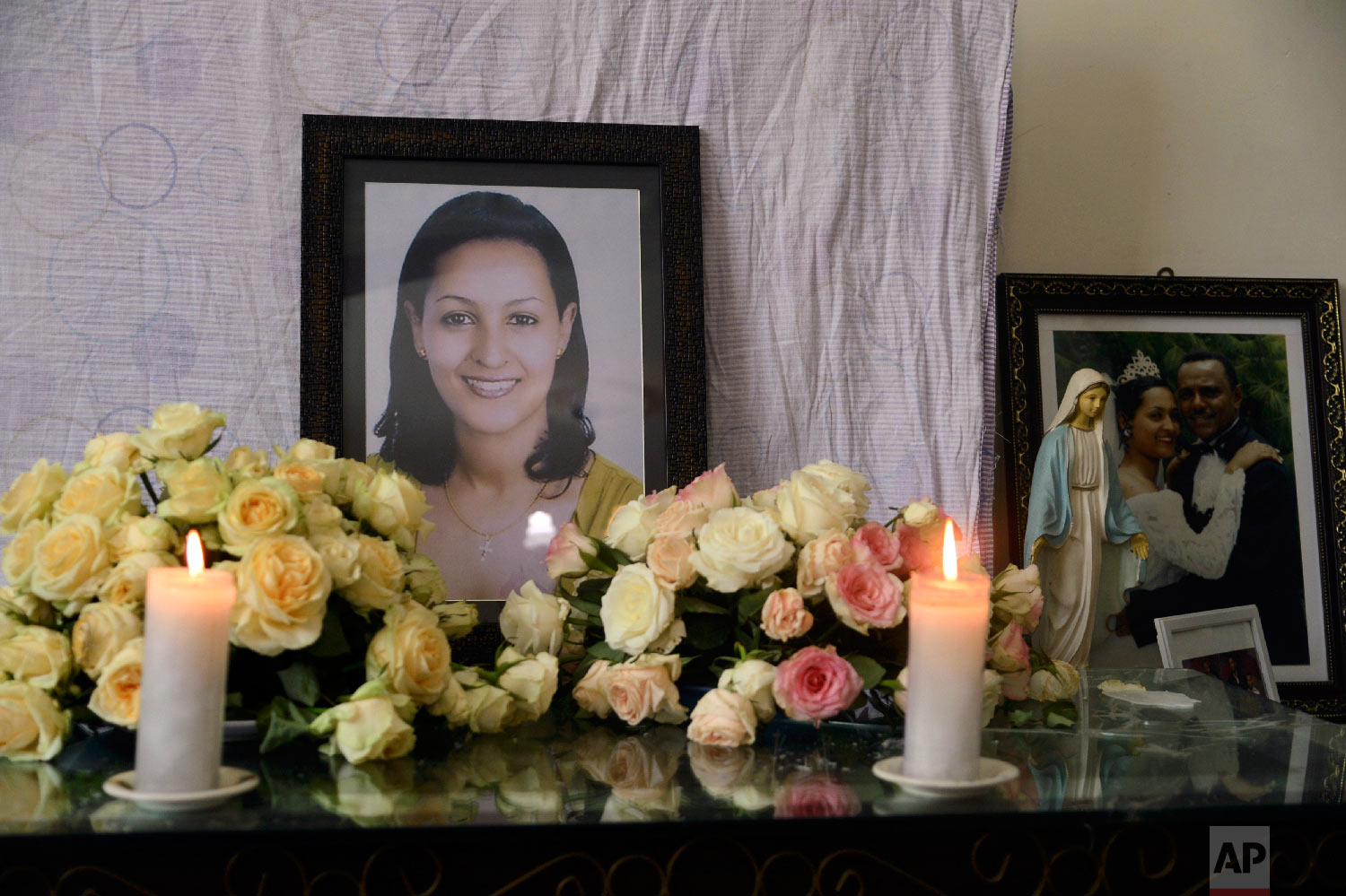 Candles burn in front of the photo of crash victim air hostess Sara Gebremichael, 38, at her house in Addis Ababa, Ethiopia, March 13 2019. (AP Photo/Samuel Habtab)