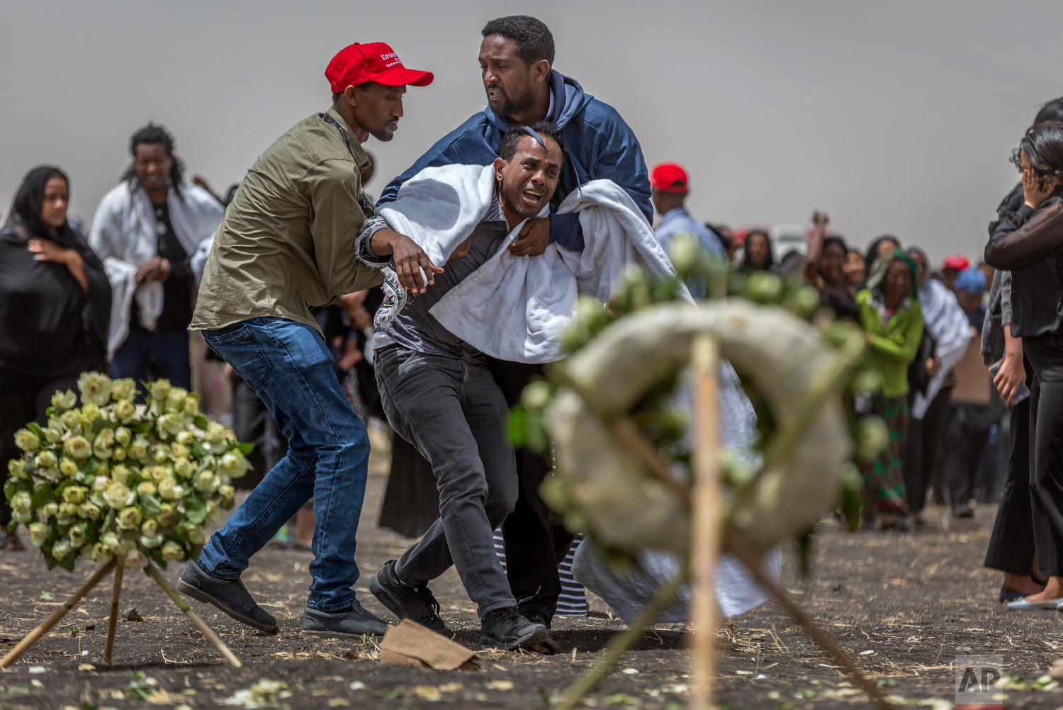 Ethiopian relatives of crash victims mourn and grieve at the scene where the Ethiopian Airlines Boeing 737 Max 8 crashed shortly after takeoff on Sunday near Bishoftu, Ethiopia on March 14, 2019. (AP Photo/Mulugeta Ayene)