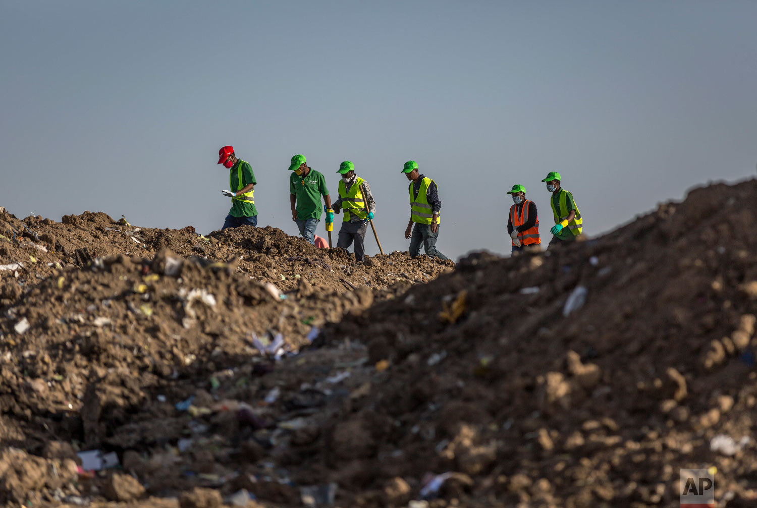 Workers walk to collect clothes and other materials, under the instruction of investigators March 12, 2019. (AP Photo/Mulugeta Ayene)