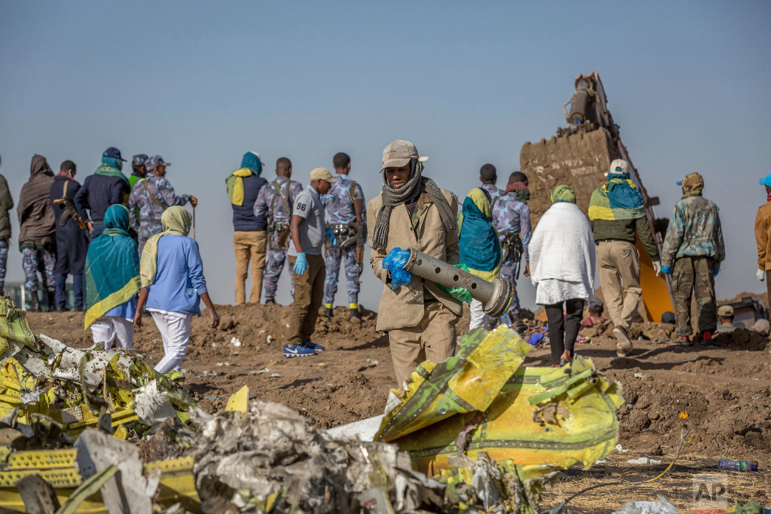 Workers gather at the scene of an Ethiopian Airlines flight crash near Bishoftu, Ethiopia, March 11, 2019. (AP Photo/Mulugeta Ayene)
