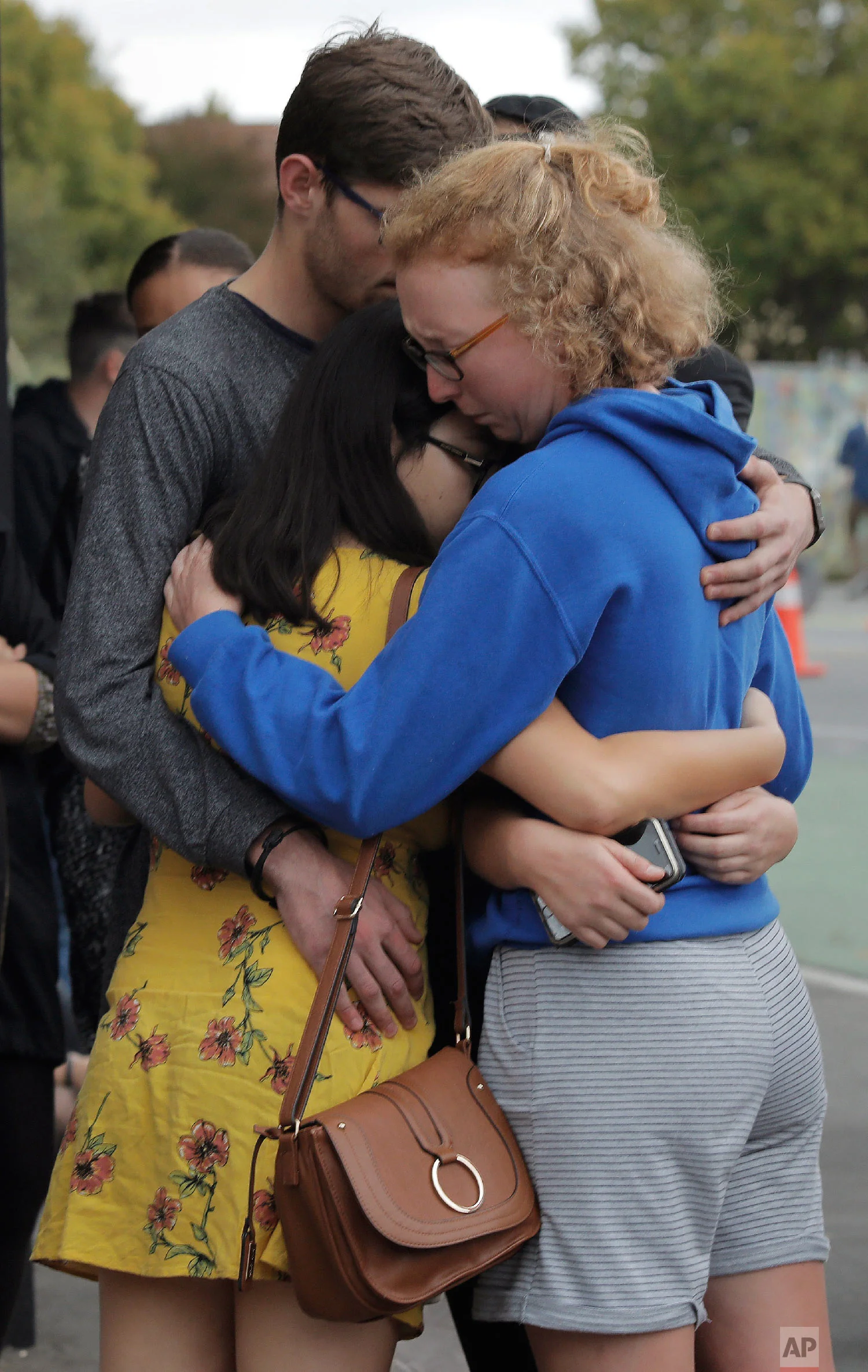 Mourners hug as they pay their respects at a makeshift memorial near the Masjid Al Noor mosque in Christchurch, New Zealand, Saturday, March 16, 2019, where one of the two mass shootings occurred.(AP Photo/Vincent Yu)