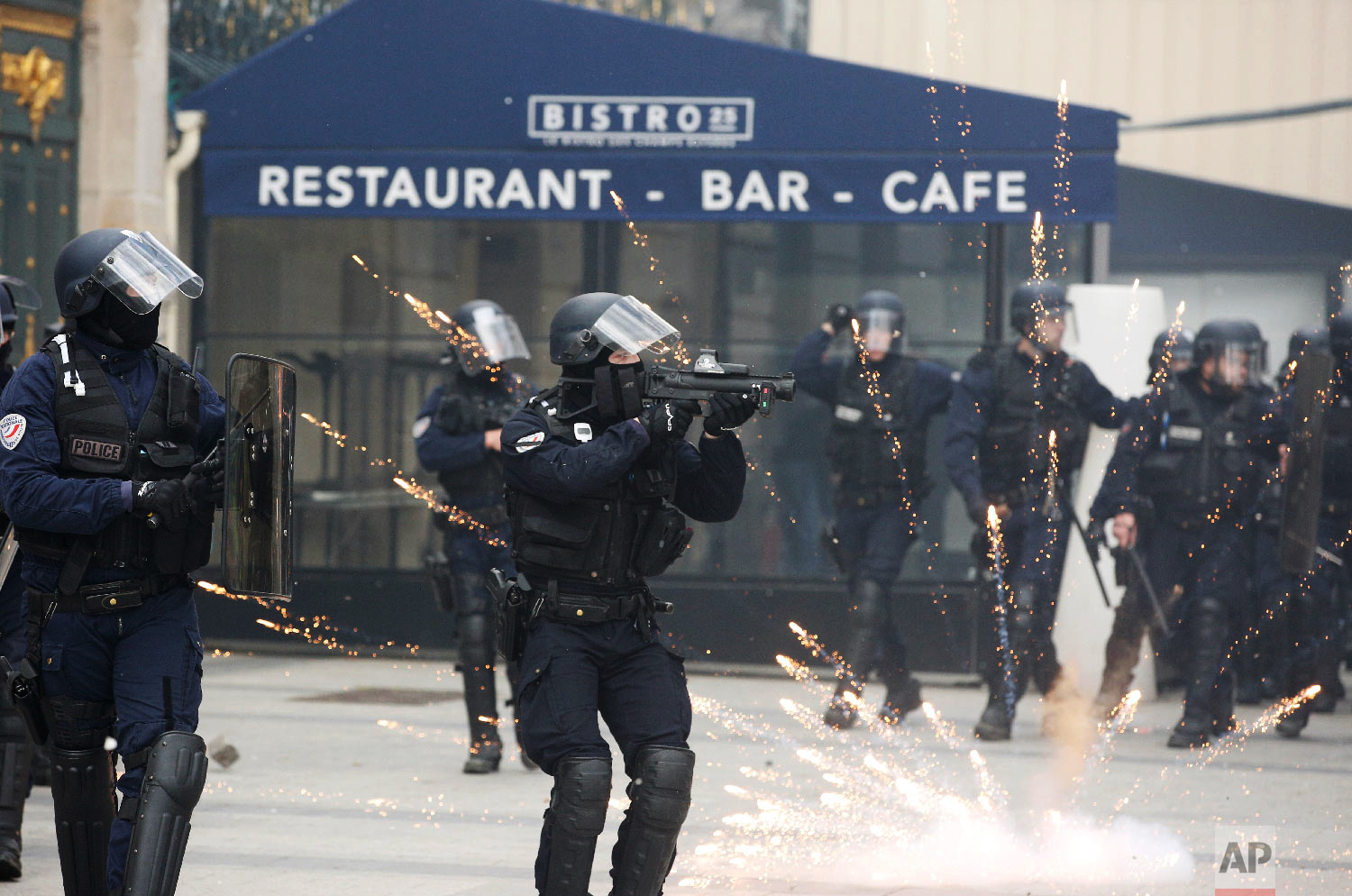 A riot police officer aims at a yellow vests demonstration on the Champs Elysees avenue March 16, 2019, in Paris. (AP Photo/Christophe Ena)