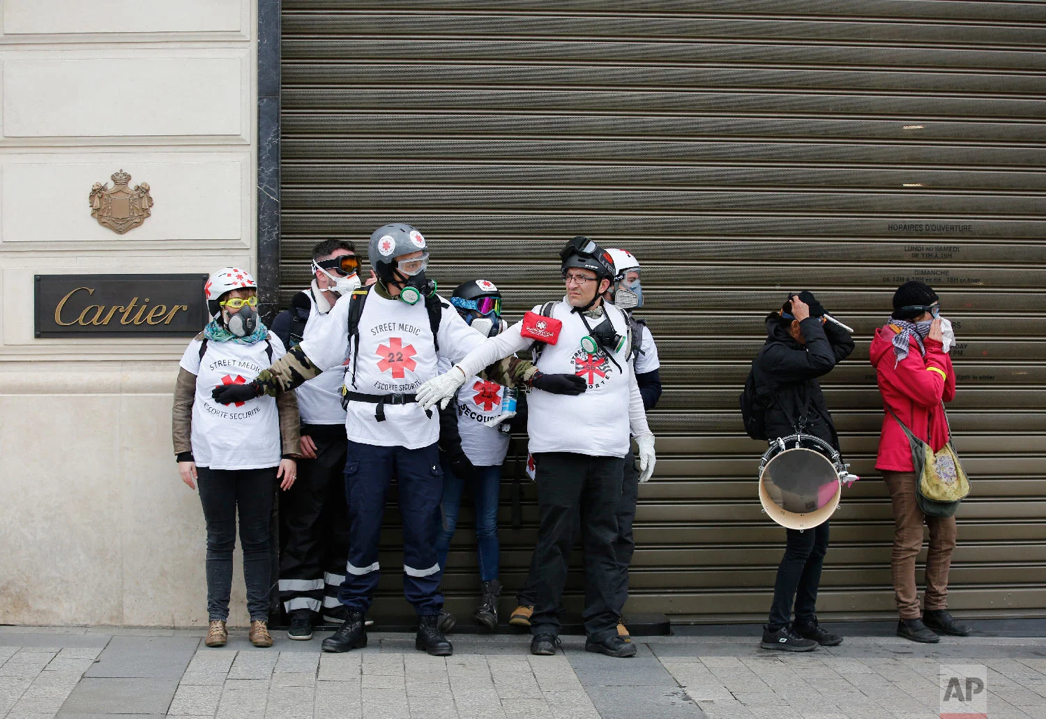 Street medics wait during a yellow vests demonstration, Saturday, March 16, 2019, in Paris. (AP Photo/Christophe Ena)