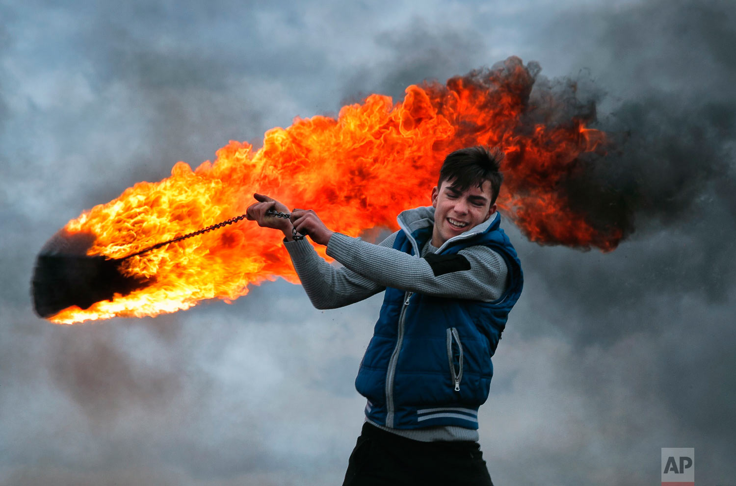 A young man spins a burning tire on a metal chain, during a ritual marking the upcoming Clean Monday, the beginning of the Great Lent, 40 days ahead of Orthodox Easter, on the hills surrounding the village of Poplaca, in central Romania's Transylvania region, Sunday, March 10, 2019. (AP Photo/Vadim Ghirda)