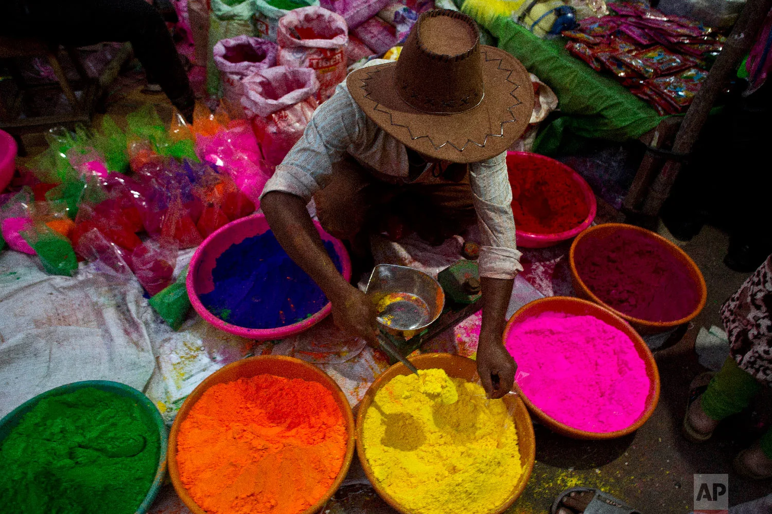 An Indian street vendor sells colored powder a day ahead of Holi, March 20, 2019. (AP Photo/Anupam Nath)