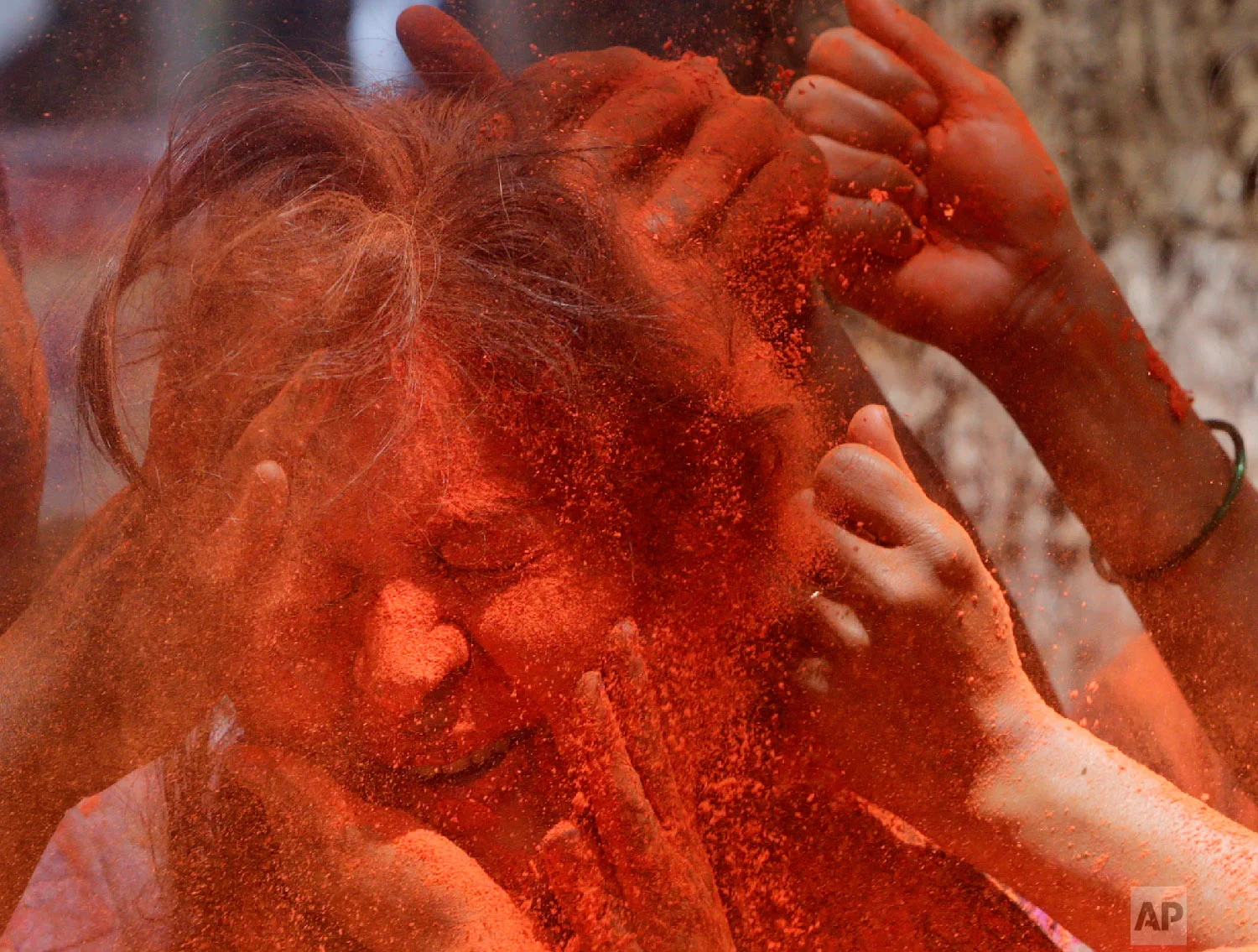 Revelers smear colored powder on a woman during celebrations marking Holi, the Hindu festival of colors, in Mumbai, India, March 21, 2019. (AP Photo/Rajanish Kakade)