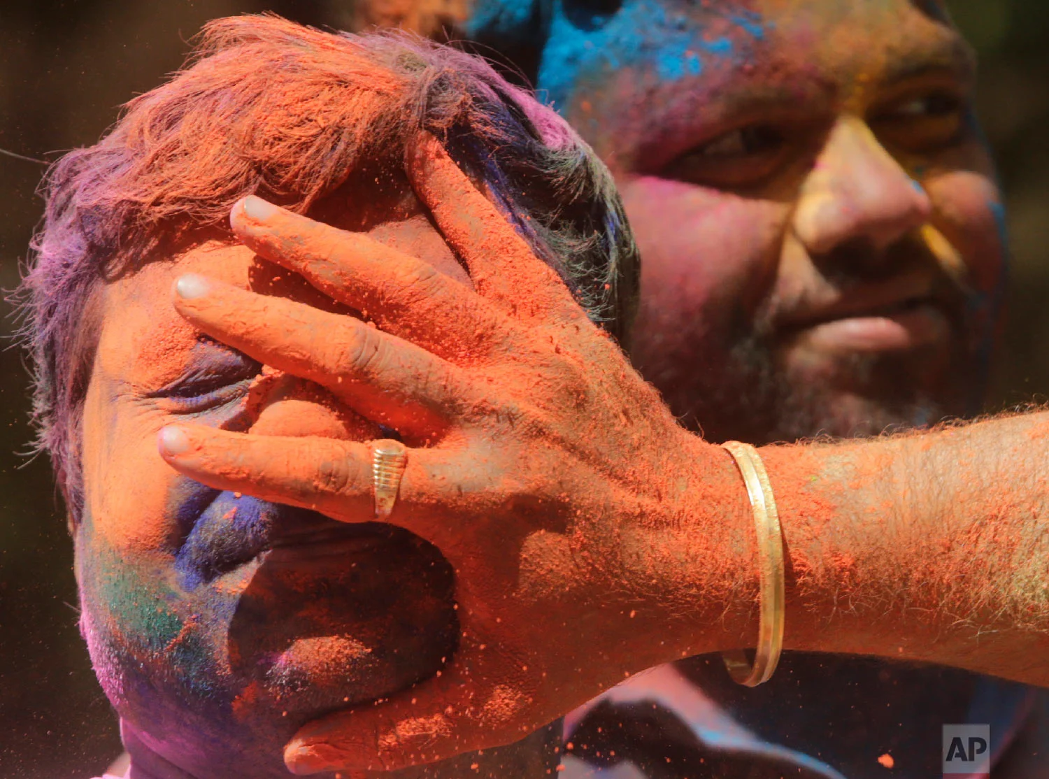 Revelers smear colored powder on a man during celebrations marking Holi, the Hindu festival of colors, in Mumbai, India, March 21, 2019. (AP Photo/Rajanish Kakade)