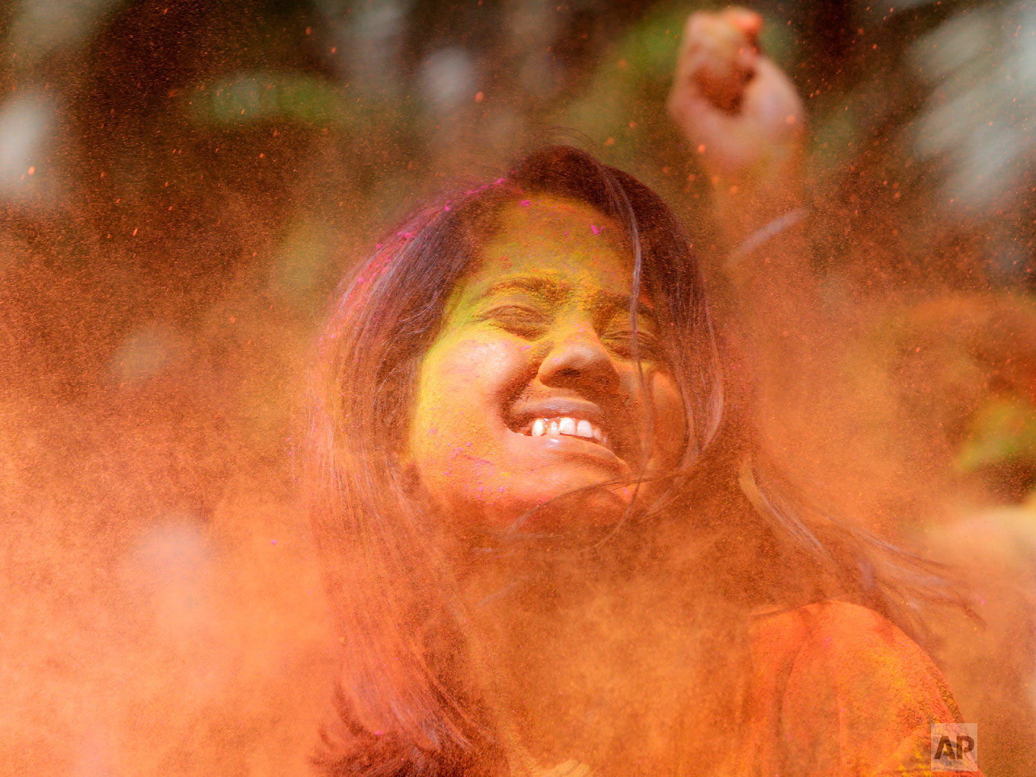 Revelers throw colored powder on a woman during celebrations marking Holi, the Hindu festival of colors, in Mumbai, India, Thursday, March 21, 2019. (AP Photo/Rajanish Kakade)