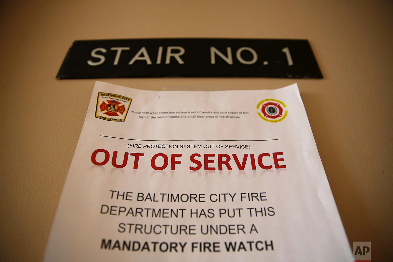 In this Feb. 22, 2019 photo, a sign alerts residents in Rosemont Tower in Baltimore that the fire sprinkler system is out of service, requiring a firefighter to stand watch around the clock. (AP Photo/Patrick Semansky)