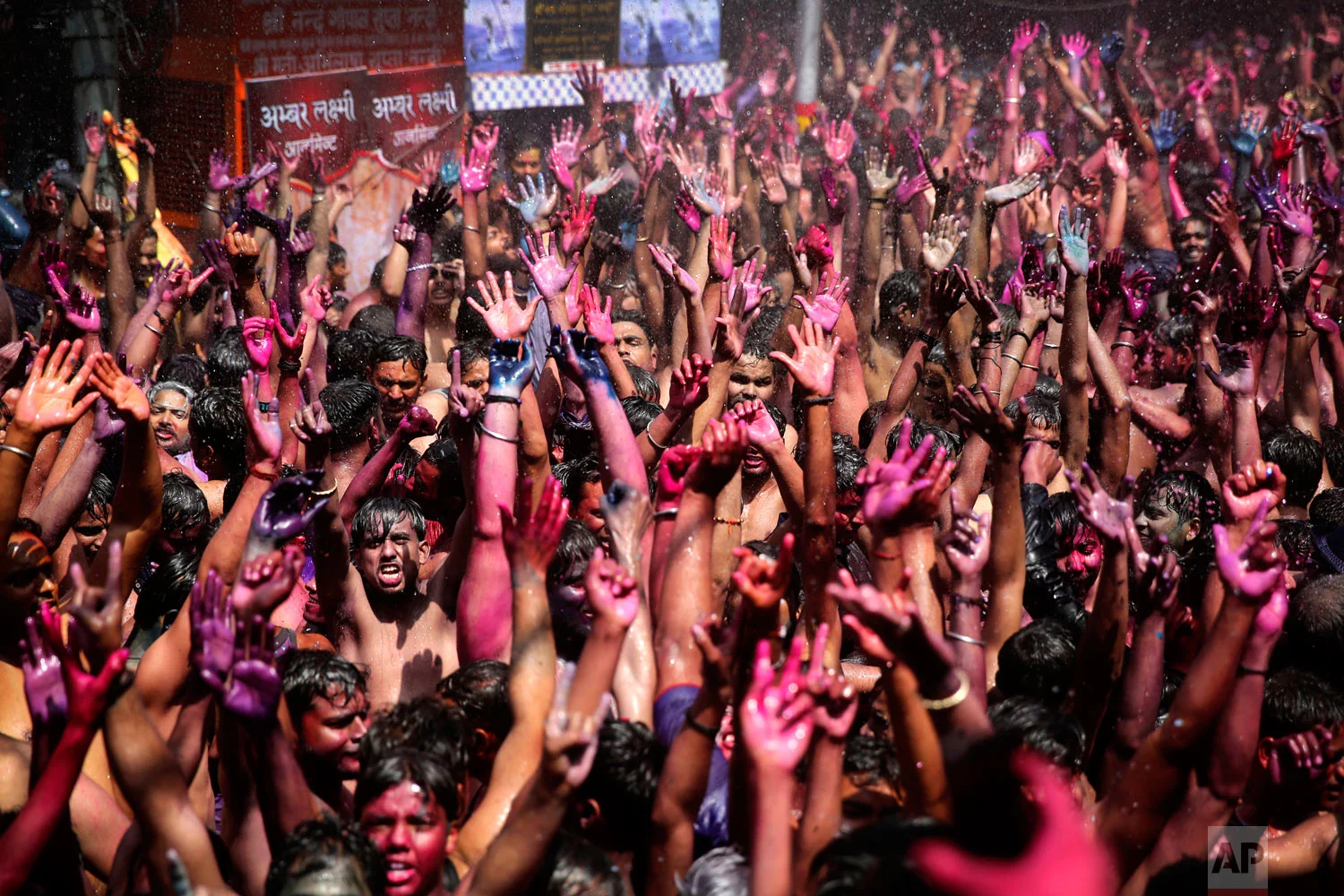 Indian revelers, faces smeared with colored powder, dance during Holi celebrations, or the Hindu festival of colors in Prayagraj, India, Friday, March 22, 2019. (AP Photo/ Rajesh Kumar Singh)