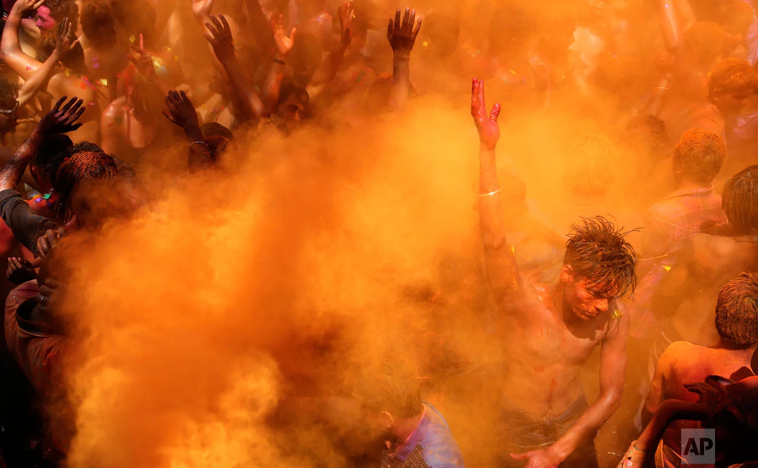 Indian revelers dance as color is sprayed on them during celebrations to mark Holi, the Hindu festival of colors, in Prayagraj, India, Friday, March 22, 2019. (AP Photo/ Rajesh Kumar Singh)