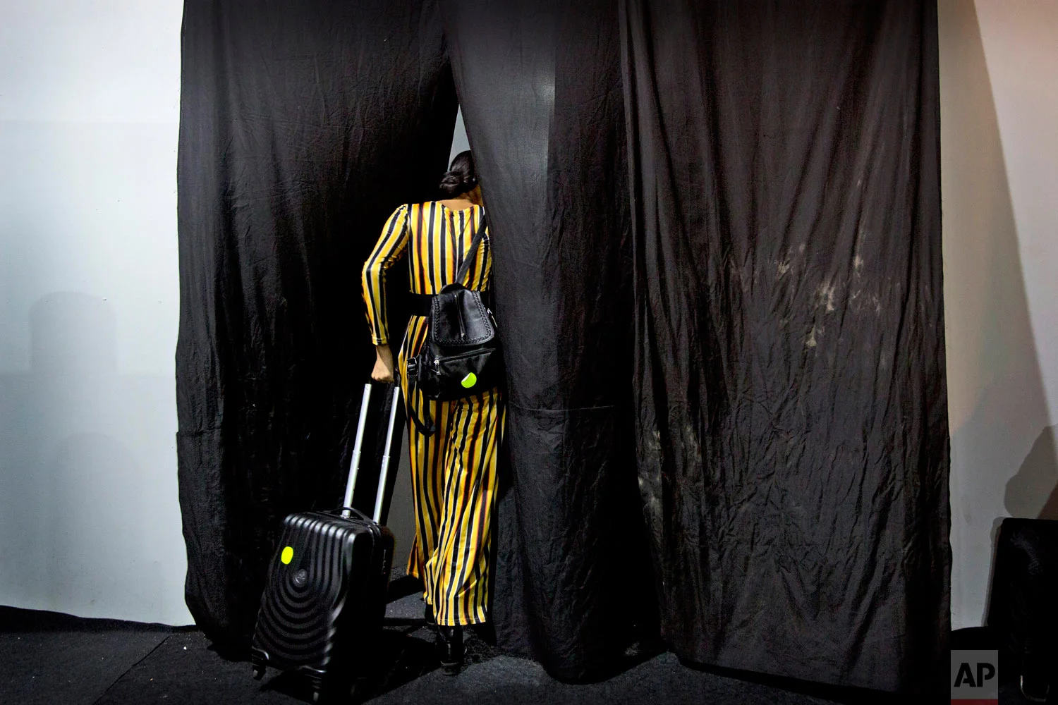 A model leaves the changing area after showcasing creations of Indian designers for the Lotus Makeup India Fashion Week, on Thursday, March 14, 2019, in New Delhi, India. (AP Photo/Manish Swarup)